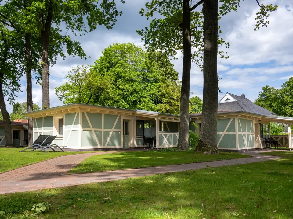 Ensemble aus renovierten Bungalows im Grünen, in harmonischer Farbgestaltung und gepflegter Umgebung – ausgeführt von MALER GROSSER im Falk Seehotel Plau am See.